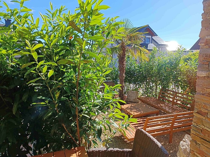 Ferienwohnung Chalet Seenähe - Palmengarten mit Loungeecke