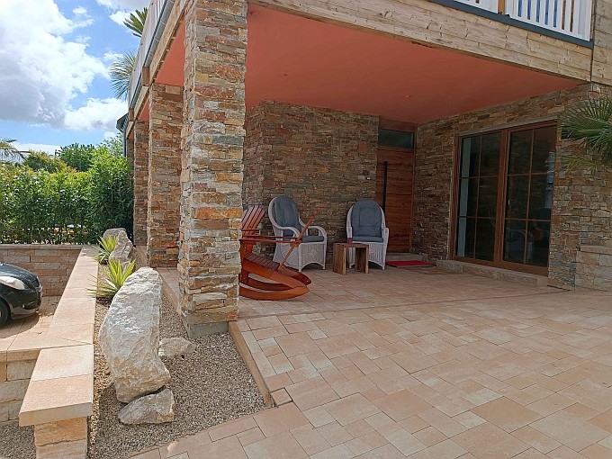 Ferienwohnung Chalet Seenähe - Terrasse mit Schaukelstühlen und Kolonialsesseln und Eingang