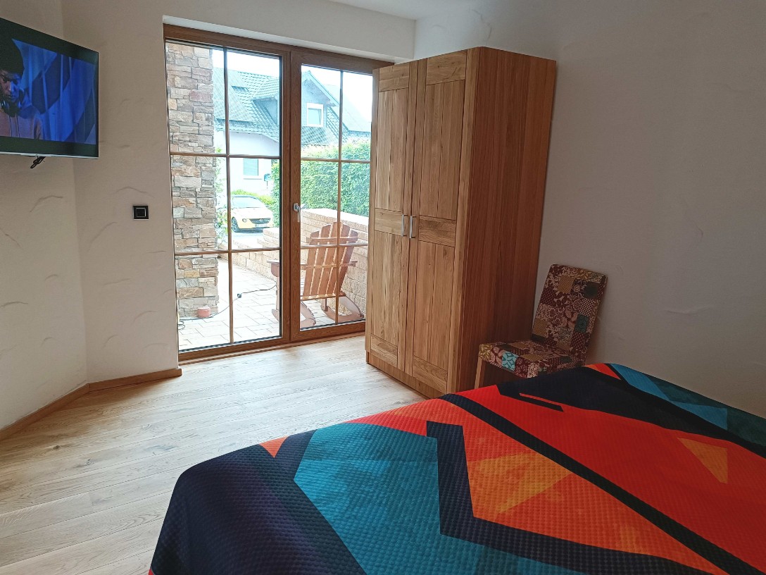 Ferienwohnung Chalet Seenähe - Schlafzimmer 2 mit TV und zus. Ausgang zur Terrasse