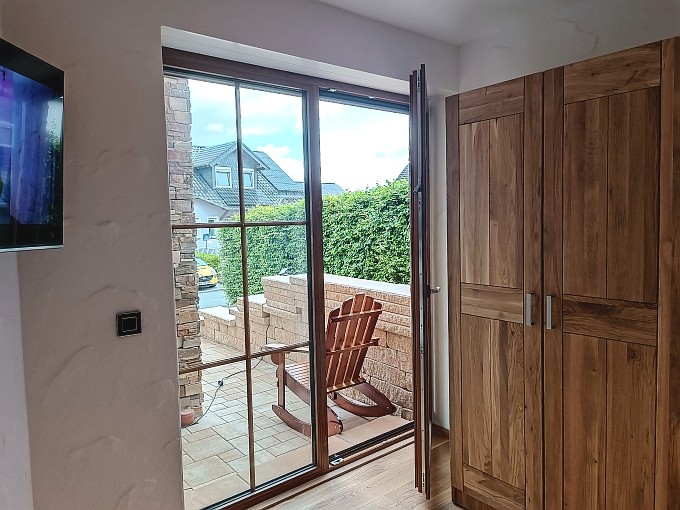Ferienwohnung Chalet Seenähe - Schlafzimmer 2 mit Ausgang zum Palmengarten und der Terrasse