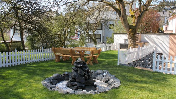 Wiese hinter dem Haus mit Grill und Springbrunnen