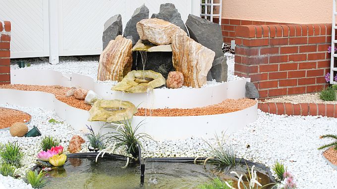Gepflegte Zierkiesanlage und Springbrunnen am Haus