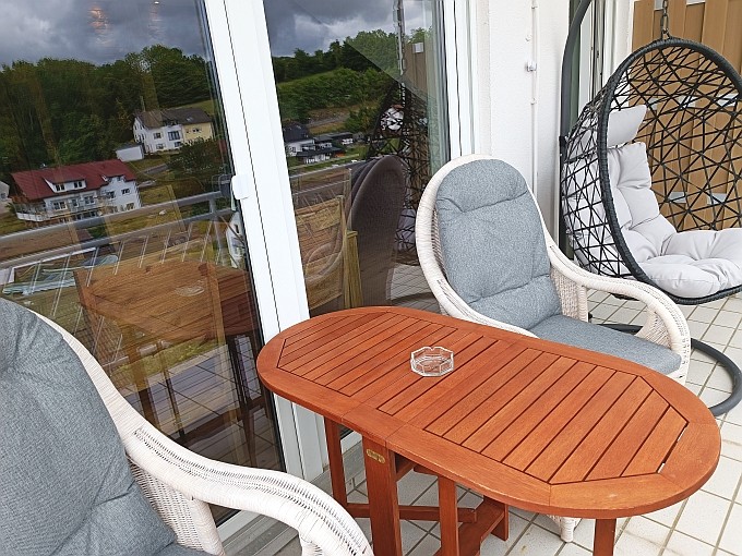 Ferienwohnung Traum-Seeblick, Balkon mit 2 Kolonialsesseln, 2 Stühlen und Hängesessel