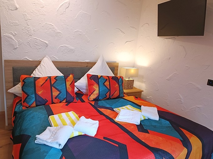 Ferienwohnung Traum-Seeblick, Schlafzimmer 1 mit 180 cm breitem Boxspringbett und TV