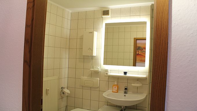 Bad mit großem beleuchteten Spiegel